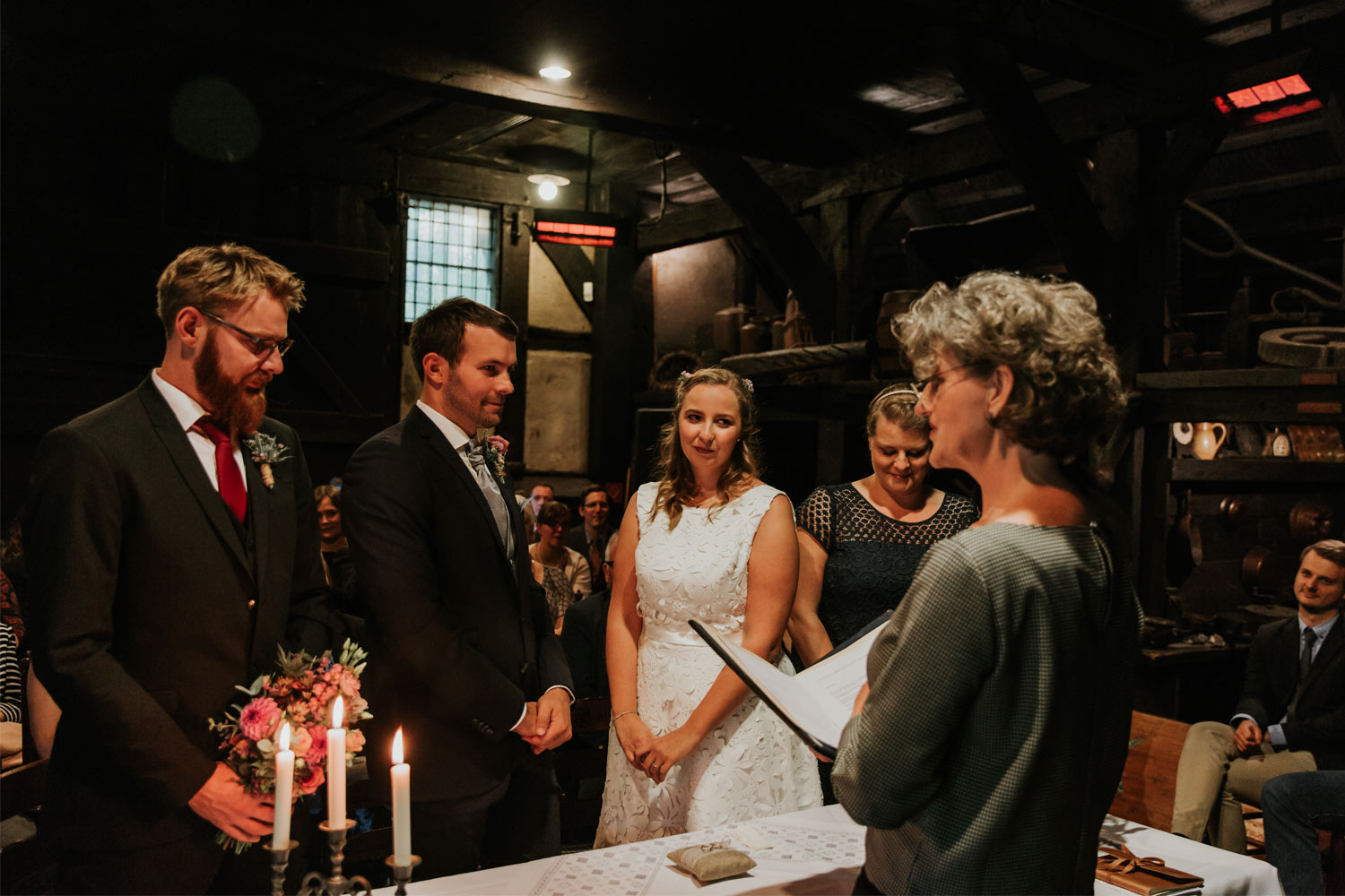 hochzeitsfotograf-muenster-standesamtliche-trauung-im-muehlenhof-brautpaar-und-hochzeitsgaeste-waehrend-der-trauung