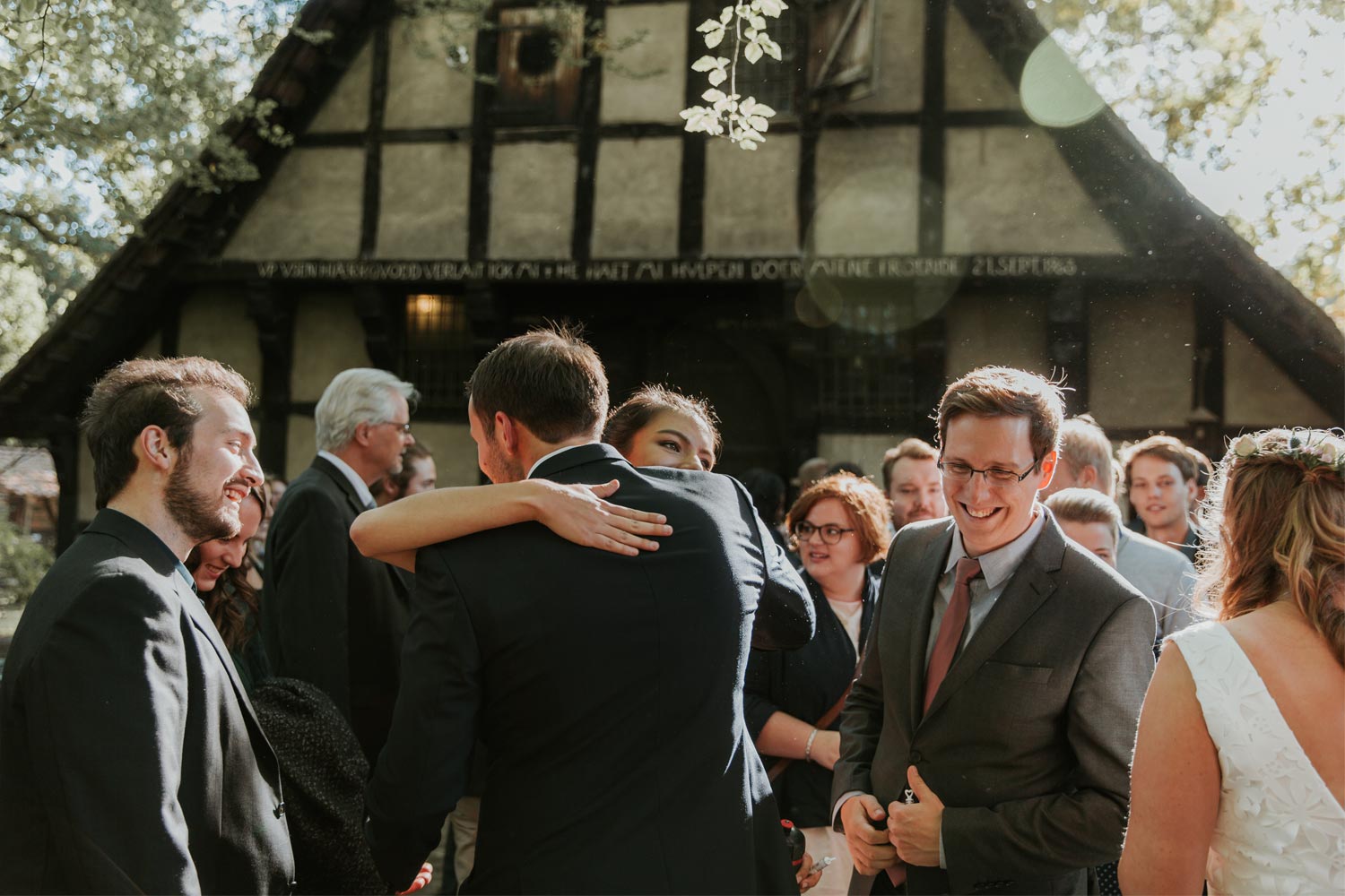 hochzeitsfotograf-muenster-standesamtliche-trauung-im-muehlenhof-brautpaar-wird-von-gaesten-gratuliert-und-umarmt